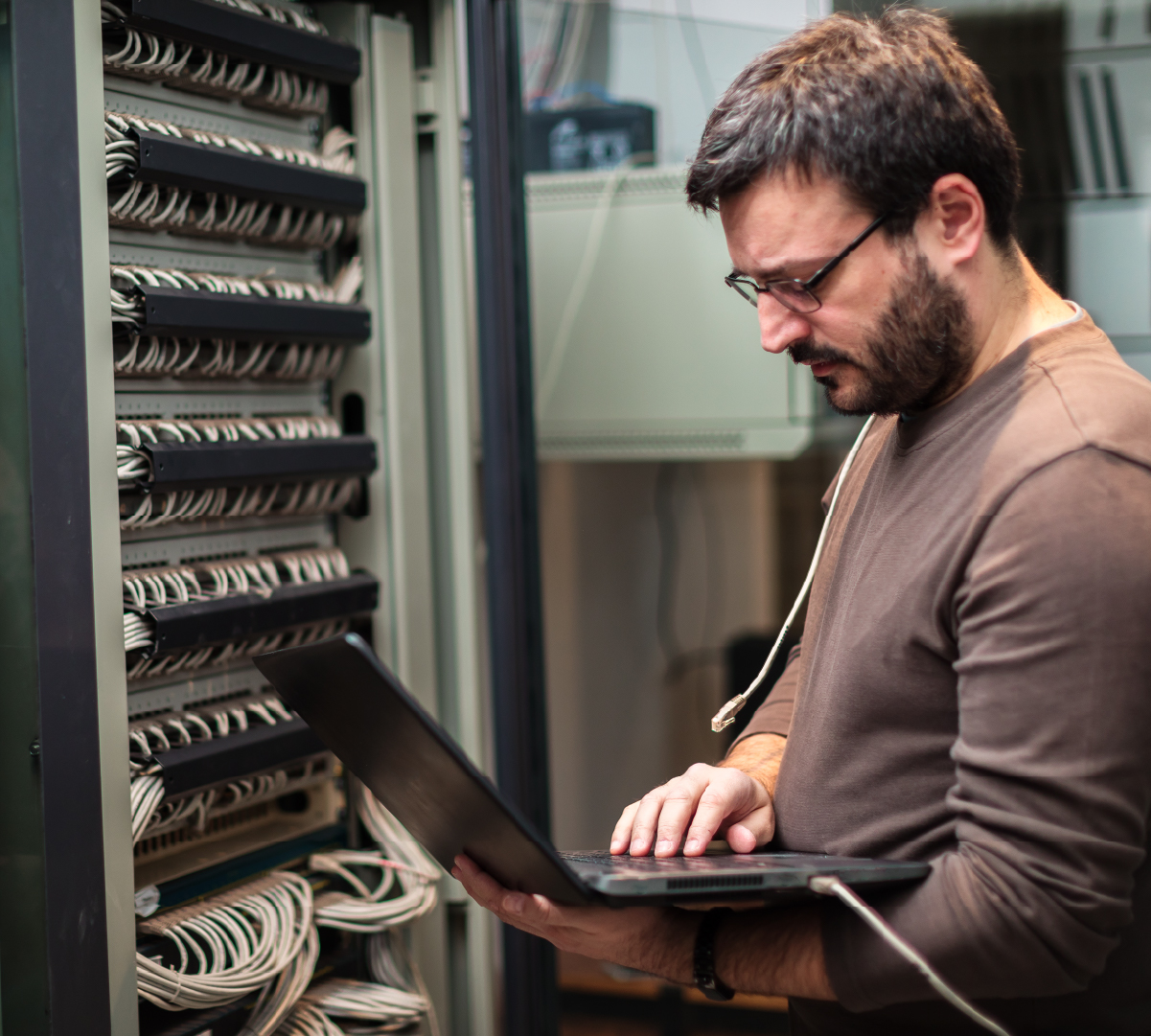 Decorative image: Technician with laptop examining servers